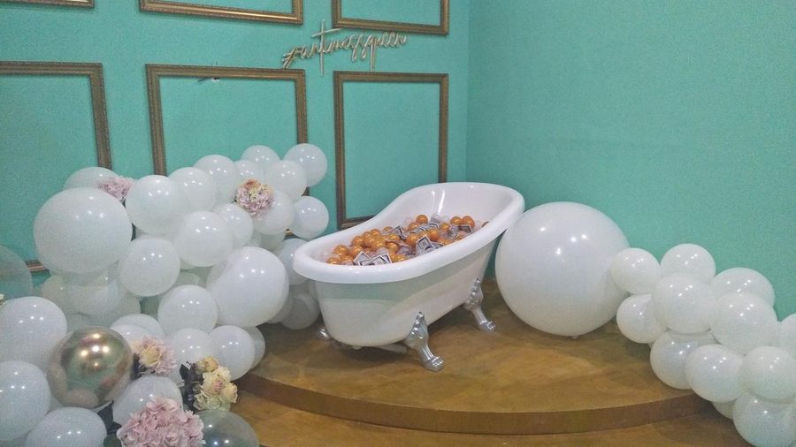 Baluun by HALUU balloon room with a white clawfoot bathtub full of orange balls among white balloons