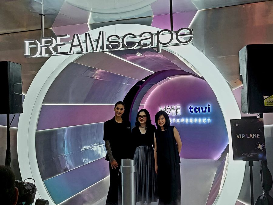 Three women standing in the illuminated circular entrance arch of DREAMscape