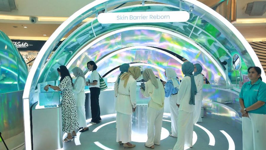 Visitors in hijabs walking through the illuminated Skin Barrier Reborn tunnel at Wardah Skinverse